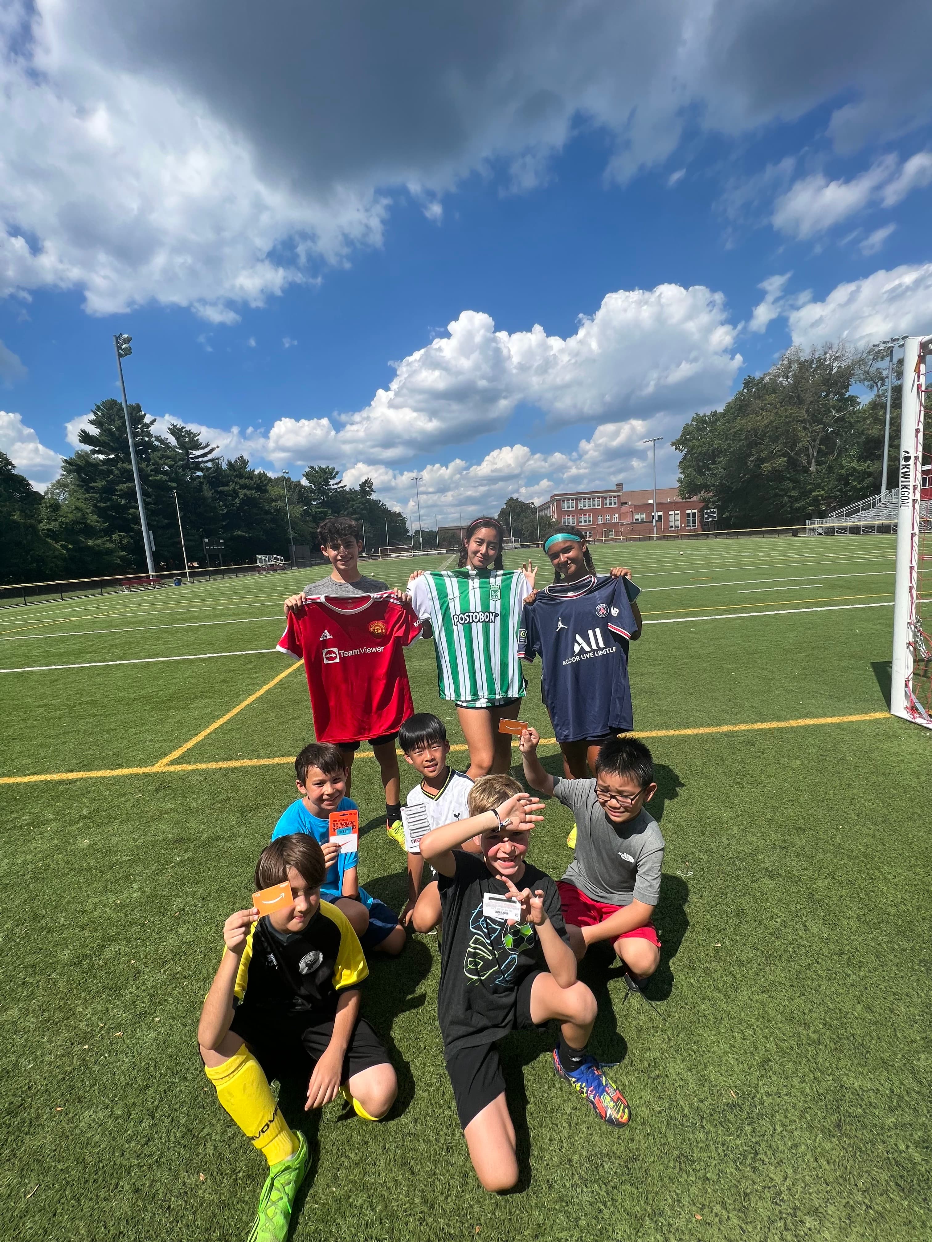 Children at our soccer camp showing team jerseys